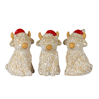 Three white and beige ceramic Highland cows with red Santa hats, viewed from different angles.