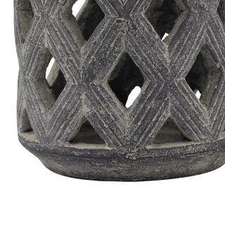 Close-up of the weathered grey ceramic lattice joining the thick, rounded base of the lantern.