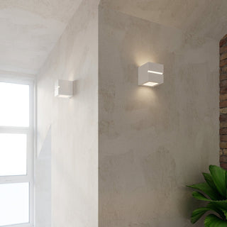 Two ceramic cubic wall lamps installed on adjacent textured walls in an interior setting.