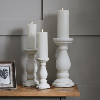 Grouping of three white ceramic candle holders showing the distressed, slightly chipped finish.