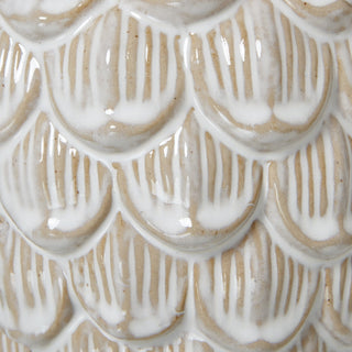 Close detail of the ceramic texture, highlighting the contrasting white glaze and exposed beige clay.