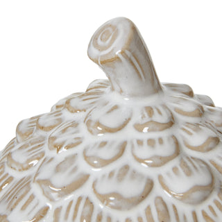 Close detail of the ceramic pine cone lid's stem handle and surrounding scales.