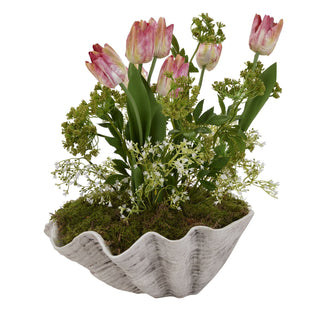 White shell planter styled with pink tulips, moss, and various green faux plants.