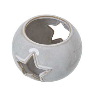 Three-quarter view of the ceramic tealight holder, showing the speckled white glaze and the star cutout.
