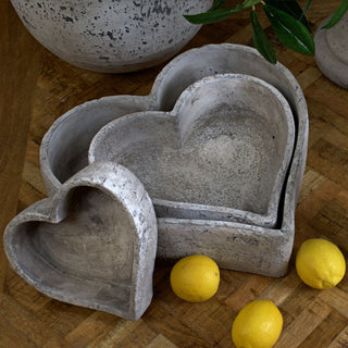 Close up of the stone-finish heart trays and lemons on a warm, patterned wooden floor.