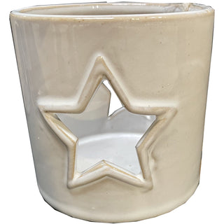 Light beige ceramic tealight holder with a large star cut-out design showing the white interior.