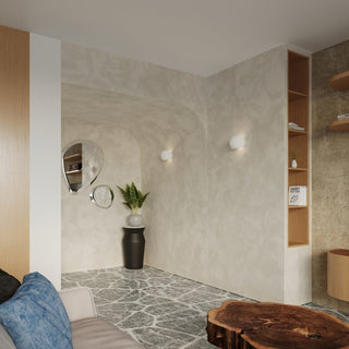 Two ceramic wall lights illuminating a contemporary room featuring textured walls, wooden shelving, and a large wood table.