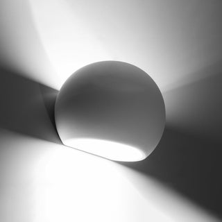 Curved ceramic wall light showing the distinctive up and down illumination pattern against the wall.