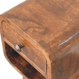 Close detail of the chestnut bedside top, showing the wood grain, curved edge, and antique brass drawer knob.