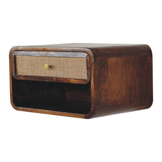 Angled view showing the woven rattan drawer front, brass knob, and open storage section.