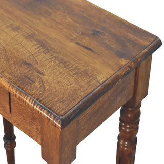 Close-up of the chestnut desktop surface, highlighting the wood grain, rounded edge profile, and upper turned leg.