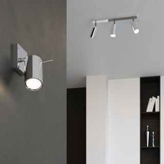 Styled room scene showing the chrome wall light and coordinating three-spot ceiling bar fitting.