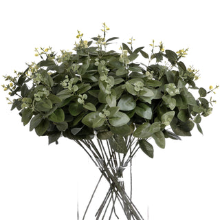 Dense bunch of artificial eucalyptus foliage displayed in a tall glass cylinder.
