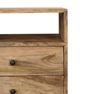 Close-up detail of the oak-ish wood grain, showing the open shelf and two drawers with small metal knobs.