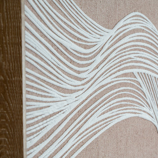 Oblique close-up showing the intersecting white wavy lines on the beige canvas and the vertical wood grain of the frame.