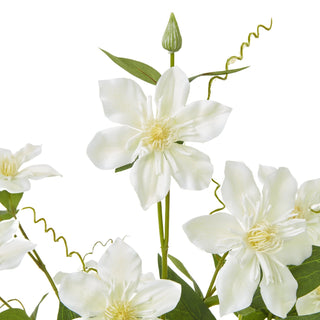 Close detail of the artificial clematis spray, highlighting the cream flowers, yellow centres, curly tendrils, and a closed bud.
