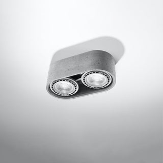 Close up, angled view showing the rough, speckled texture of the grey concrete ceiling light fitting.