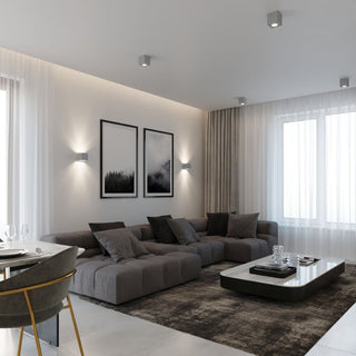 Four concrete ceiling lights providing ambient light in a modern grey living room setting.