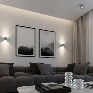 Concrete ceiling light fixture in a grey living room scene, paired with matching wall sconces.