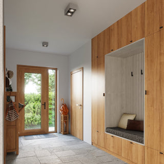 Twin spotlight concrete ceiling lamp installed in a modern entryway above built-in wooden storage.