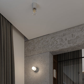 Concrete ceiling light installed above textured concrete walls and dark grey curtains in an industrial-style room.