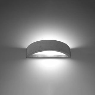 Arched concrete wall light mounted, showing the warm up and down light wash effect.