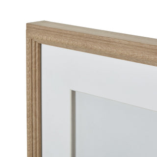 Close up of the light wood frame corner showing the wood grain texture and the grooved beaded inner edge detail.