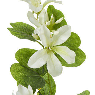 Close-up detail of the artificial cream Bauhinia flower petals and textured, veined green leaves on the stem spray.
