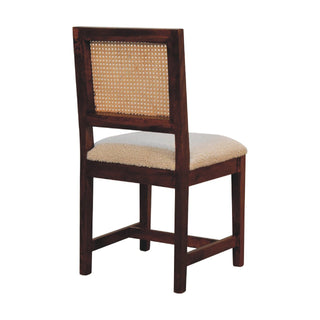 Dark wooden chair viewed from the rear, showing the cane backrest and the back legs.