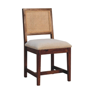 Dark wood chair frame supporting a woven rattan back panel and thick cream boucle seat.