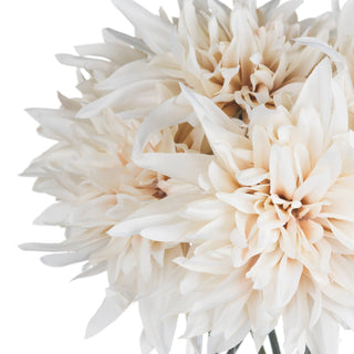 Extreme close-up showing the dense arrangement of several artificial cream dahlia blooms against a white background.