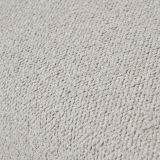 Extreme close-up of the dense, looped texture of the cream upholstery fabric.