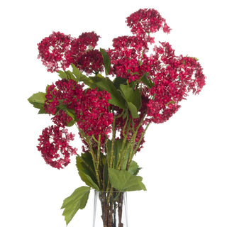 Bunch of artificial crimson viburnum stems and leaves in a clear vase, studio shot on white.