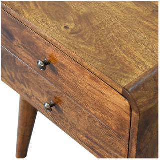 Detail shot showing the rich chestnut wood grain on the top surface and drawer fronts, featuring the small metal handles.