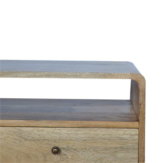 Detail showing the curved side panel, open shelf, and drawer front with a small metal knob.