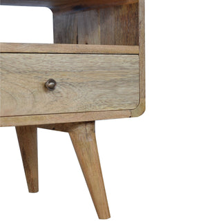 Detail of the curved drawer front, antique brass knob, and angled mid-century style wooden legs.