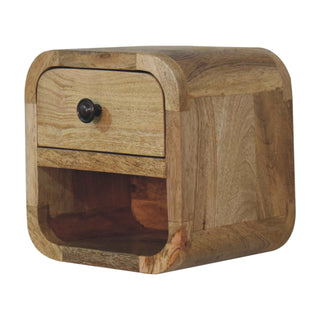 Angled view of the oak-ish bedside unit showing the drawer with the metal knob and the deep, curved open storage slot.