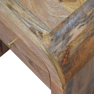 Detail of the curved wooden joint and the rich, varied grain across the bedside table's top.