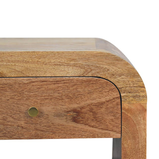 Close detail of the curved wooden corner, showing the drawer front and the small circular brass handle.