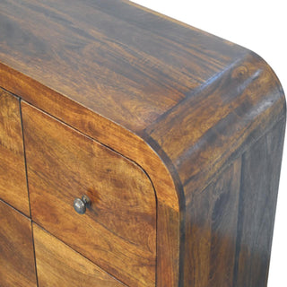 Detail showing the curved edge of the chestnut top and the rounded front of the upper drawer with a metal knob.