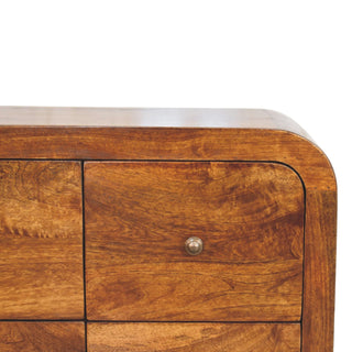 Detail shot showing the curved top edge and corner of the chestnut drawer unit, highlighting the wood grain.