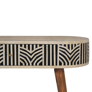 Detail of the bone inlay geometric pattern on the curved drawer front with small brass handle.