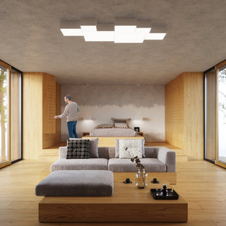 Multi-unit installation of square white ceiling lights in a modern open-plan room with wood flooring.