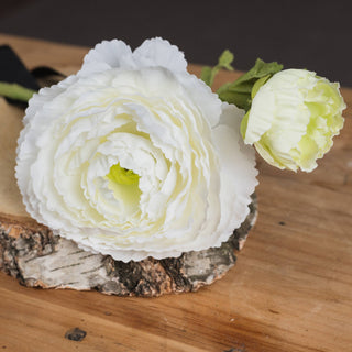 Close-up detail of the artificial white ranunculus bloom and closed bud, highlighting layered petals.