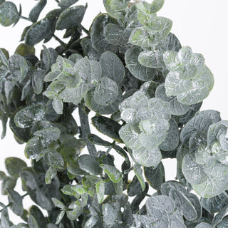 Close-up detail of the frosted green eucalyptus leaves on the candle wreath.
