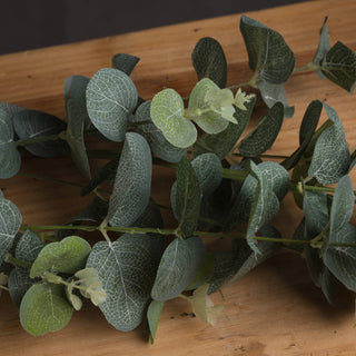 Detailed view of the artificial eucalyptus leaves, showing textured veining and pale green new growth.