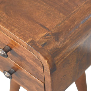 Close detail of the chestnut wood grain, showing the joint where the top surface meets the curved front panel.