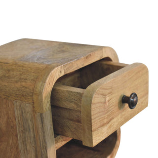 Close-up of the oak-ish bedside unit with the drawer partially open, showing the internal construction and metal knob.