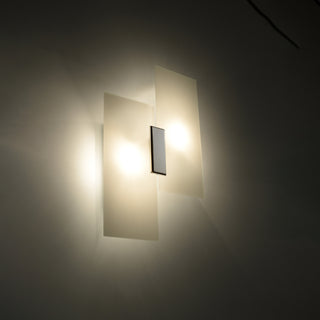 Close view of the central chrome fitting between the two illuminated rectangular frosted glass panels.
