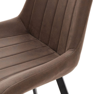 Close detail of the coffee faux leather chair showing the texture and stitched vertical ribbing.